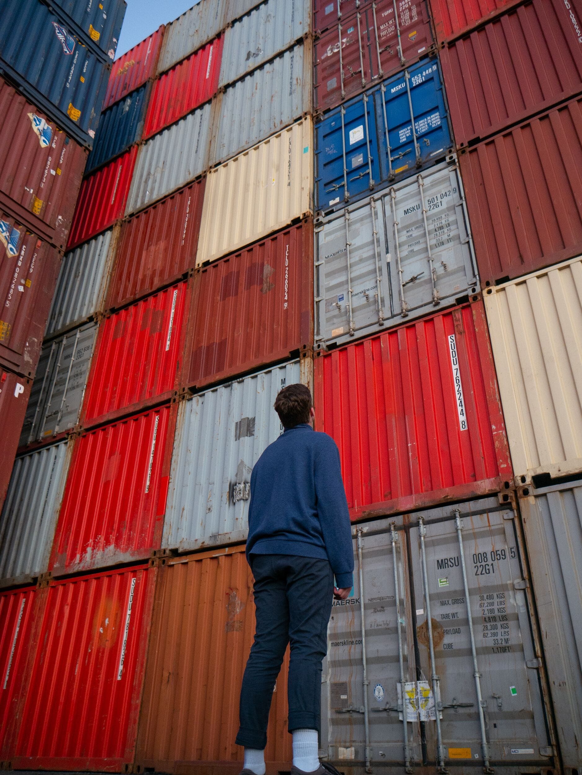 Man kijkend naar containers die naar Griekenland verscheept worden